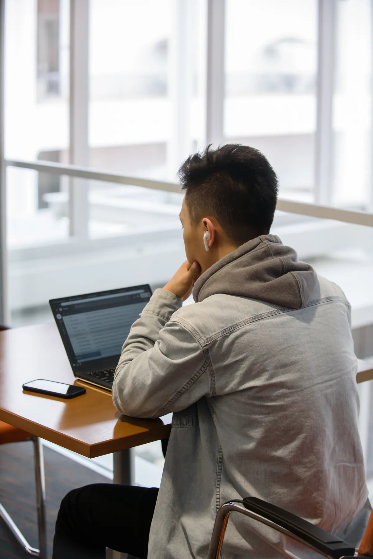 Student sitting at a table working on their laptop